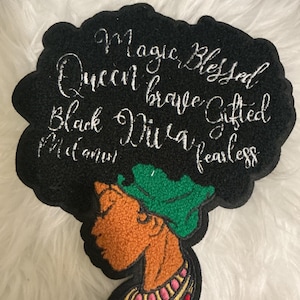 May include: A black embroidered patch shaped like an afro hairstyle featuring the silver stitched words Magic, Blessed, Queen, brave, Gifted, Black, Diva, fearless, and Melanin. Below the hair is a profile of a person with orange skin, a green headwrap, and a colourful necklace.