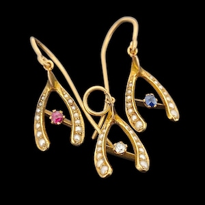 May include: A pair of gold horseshoe earrings with pearl accents and a ruby, sapphire, and diamond in the centre of each horseshoe.