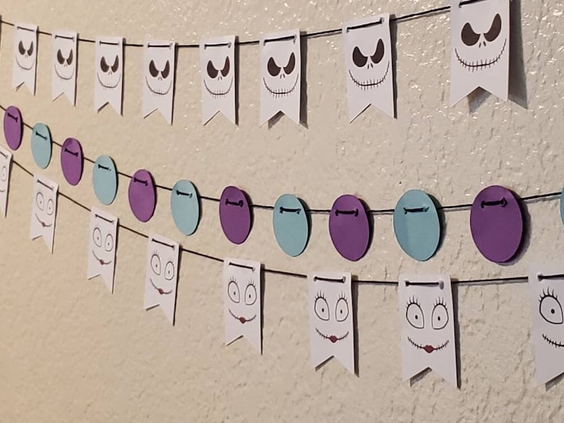 Pu&ograve; includere: Uno striscione per una festa di Halloween con bandierine bianche che raffigurano il volto di Jack Skellington e un secondo striscione con cerchi viola, blu e bianchi.