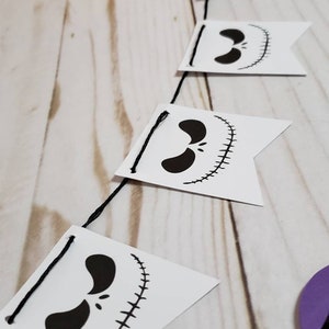 Pu&ograve; includere: Uno striscione di Jack Skellington in bianco e nero con una corda di bandiere. Ogni bandiera presenta un'illustrazione in bianco e nero del viso di Jack Skellington.