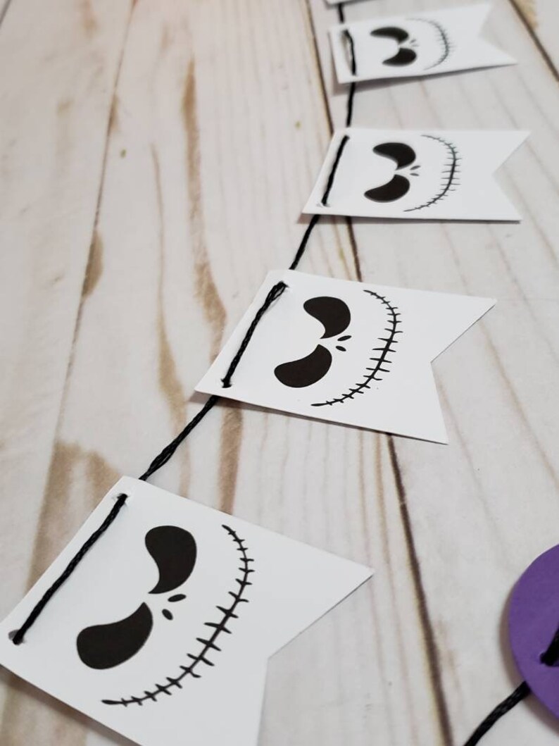 Pu&ograve; includere: Uno striscione di Jack Skellington in bianco e nero con una corda di bandiere. Ogni bandiera presenta un'illustrazione in bianco e nero del viso di Jack Skellington.