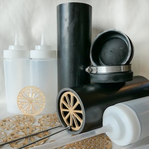 May include: A set of black plastic tubes with a gold-colored metal grate, a silver clamp, and a black rubber cap. There are also four white plastic squeeze bottles and several gold-colored metal decorative pieces.