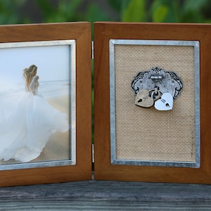 May include: A wooden picture frame with two compartments. The left side features a photo of a bride in a white dress. The right side has a burlap background with two heart-shaped padlocks hanging from a decorative metal piece.
