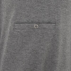 May include: A gray t-shirt with a single pocket on the front. The pocket has a metal ring on the top.
