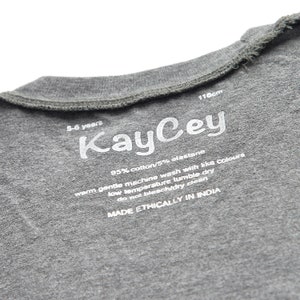 May include: Gray cotton t-shirt with a white label that says "KayCey" and includes care instructions. The label also says "95% cotton/5% elastane", "warm gentle machine wash with like colours", "low temperature tumble dry", "do not bleach/dry clean", and "MADE ETHICALLY IN INDIA".