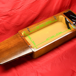 Puede incluir: Una caja de madera con una tapa con bisagras, que mide 37,3 cm por 18 cm. La caja está abierta, revelando un interior beige. La caja tiene un pequeño compartimento con una tapa negra.