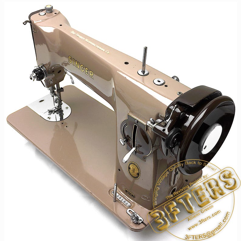May include: A vintage Singer sewing machine in a tan and brown color scheme. The machine has a shiny, metallic finish and features various dials, levers, and a large black flywheel. The Singer logo is visible on the machine.