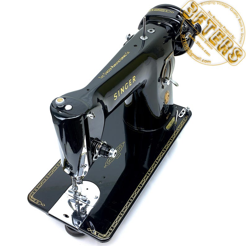 Puede incluir: Una m&aacute;quina de coser Singer negra vintage con detalles dorados. La m&aacute;quina presenta el logotipo de Singer y el texto "The Singer Manufacturing Co.". La base tiene un borde dorado decorativo. La m&aacute;quina est&aacute; sobre un fondo blanco.