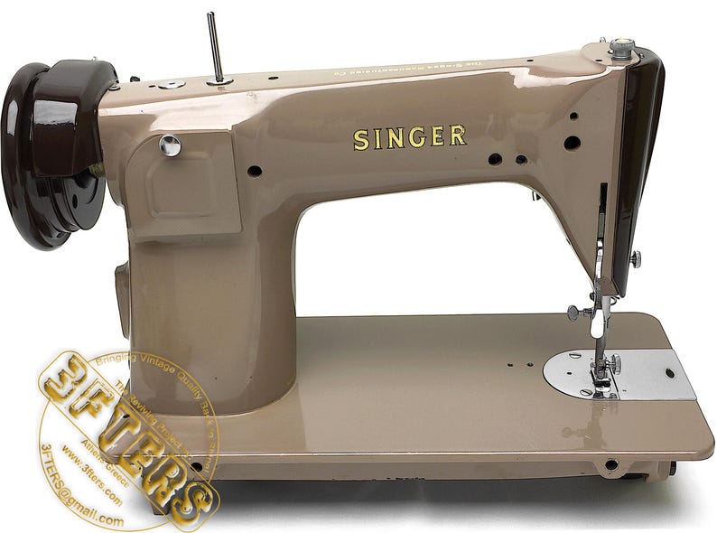 May include: A vintage Singer sewing machine in a beige color, with the brand name in gold lettering. The machine has a dark brown flywheel and a silver needle and presser foot. The machine is on a white background.