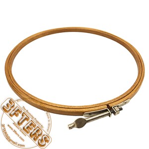 May include: A wooden embroidery hoop with a metal tightening mechanism. The hoop is round and has a natural wood finish.