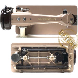 May include: Vintage Singer sewing machine in tan and brown. The machine has a curved arm and a base with intricate mechanical components. The Singer Manufacturing Co. is printed on the arm. The machine is in good condition.