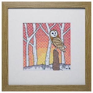May include: A framed cross-stitch artwork depicting a white barn owl perched on a tree stump in a woodland setting. The background features a gradient of red, orange, and yellow colours, creating a sunset effect. The owl's eyes are black and its feathers are brown and white.