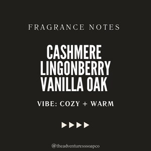 Puede incluir: Un gr&aacute;fico en blanco y negro con el texto "FRAGRANCE NOTES" en blanco, seguido de "CASHMERE LINGONBERRY VANILLA OAK" en blanco, y "VIBE: COZY + WARM" en blanco. El texto est&aacute; sobre un fondo negro con un borde rayado azul y blanco.