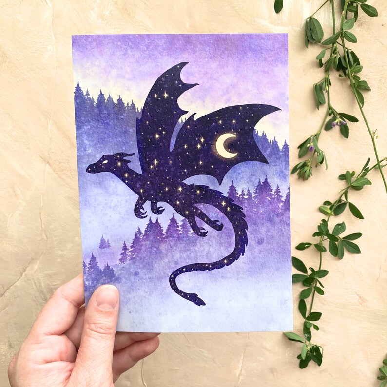 May include: A fantasy art print featuring a dragon silhouette filled with stars and a crescent moon. The dragon is set against a backdrop of a purple forest and a gradient sky. The artwork evokes a magical, celestial theme.