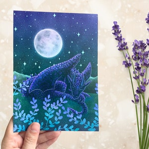 May include: A watercolor painting of a purple dragon sleeping under a full moon in a field of blue and green foliage.