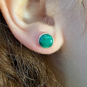 May include: A pair of green malachite stud earrings with silver settings.