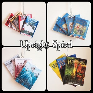 May include: A set of five book ornaments, each with a different cover. The ornaments are made of paper and are attached to a silver chain. The books include "When We Were Very Young", "Now We Are Six", "The House at Pooh Corner", "Winnie-the-Pooh", and "The Story of  Winnie-the-Pooh".