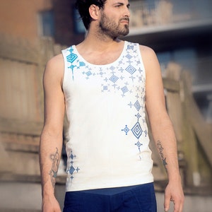 May include: A white tank top with a blue and white geometric pattern. The tank top has a scoop neck and a relaxed fit.
