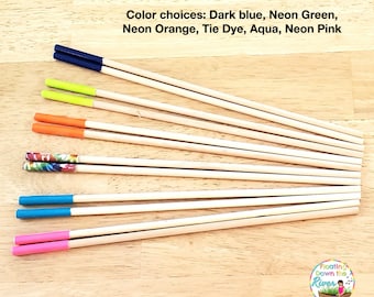 May include: Ten wooden craft sticks with different colored tips. The colors are dark blue, neon green, neon orange, tie dye, aqua, and neon pink. The text "Floating Down the River" is visible in the lower right corner of the image.