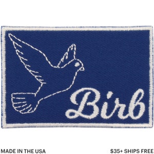 May include: A rectangular patch with a blue background and a white embroidered outline of a bird in flight. The word "Birb" is written in white script below the bird. The patch is bordered with white stitching.