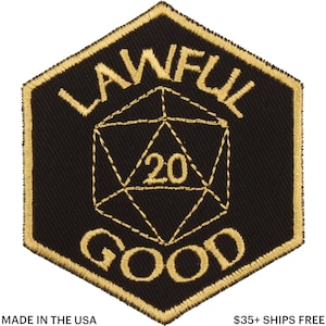 May include: Black and gold embroidered patch with the words "LAWFUL GOOD" and a D20 die with the number 20 in the center. The patch is in a hexagonal shape with gold stitching.