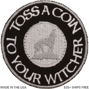 May include: Round black patch with white embroidered text that reads "TO TOSS A COIN TO YOUR WITCHER". A gray wolf silhouette is in the center. The patch is made in the USA.