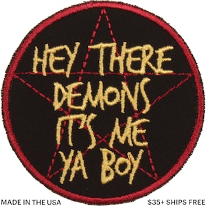 Op de afbeelding: Zwarte, ronde patch met een rode rand en een rood pentagram ontwerp. De patch heeft de geborduurde tekst "HEY THERE DEMONS IT'S ME YA BOY" in gouddraad. De tekst "MADE IN THE USA" is ook zichtbaar.