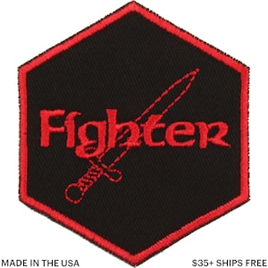 Puede incluir: Parche bordado negro y rojo con la palabra "Fighter" y un diseño de espada. El parche tiene un fondo negro con borde y letras rojas. Hecho en los EE. UU.