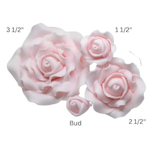May include: Pale pink artificial roses in various sizes. The largest rose measures 3 1/2 inches, with others at 2 1/2 inches and 1 1/2 inches. A bud is also included. These decorative flowers are ideal for crafting or event decor.