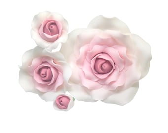 May include: A collection of five artificial roses in varying sizes. The roses have white petals with pink centers, creating a soft, delicate appearance. The arrangement is set against a plain white background.