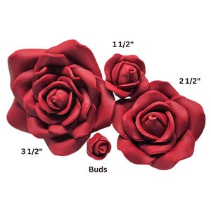 May include: A collection of burgundy-colored artificial roses in various sizes. The largest rose measures 3 1/2 inches, with others at 2 1/2 inches and 1 1/2 inches. A small bud is also included. These decorative flowers are ideal for crafts.