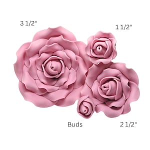 May include: Pink artificial rose flowers in various sizes, including a large 3 1/2 inch bloom and smaller buds. The image shows several flowers and buds, perfect for crafting or decoration.