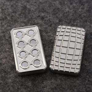 May include: Two silver rectangular fidget toys. One has a pattern of eight circular magnets, and the other has a grid pattern. The toys are displayed on a gray surface.