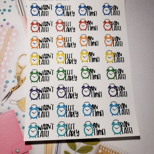 May include: A sheet of colorful alarm clock stickers with the text "Organizing Chaos" at the top. The stickers feature different colored alarm clocks with the phrases "Wasn't Late!", "Left Early", "On Time!" and "Ran Late!"