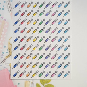 May include: A sheet of rainbow colored syringe stickers with the text "ORGANIZING CHAOS" at the top.