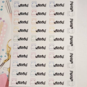 May include: A sheet of stickers with a kettlebell design and the word "WORKOUT" repeated multiple times. The stickers are in various colors, including pink, blue, yellow, and green.