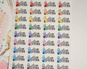 May include: A sheet of stickers with a variety of colorful aprons and the text "clean kitchen" on each. The stickers are organized in rows and columns.