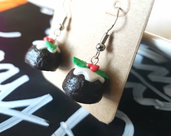 May include: A pair of silver dangle earrings with a miniature Christmas pudding charm. The pudding is brown with white icing and green holly leaves with red berries.