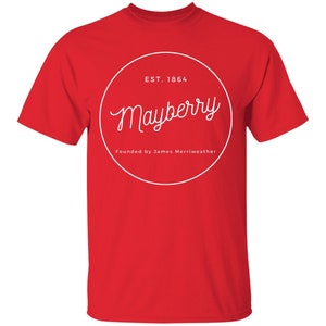 May include: Red t-shirt with a white circle graphic that says "Mayberry" in a cursive font. The circle also says "Est. 1864" and "Founded by James Merriweather".