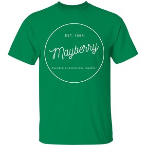 May include: Green t-shirt with a white circle graphic that says "Mayberry" with the text "EST. 1864" and "Founded by James Merriweather" underneath.