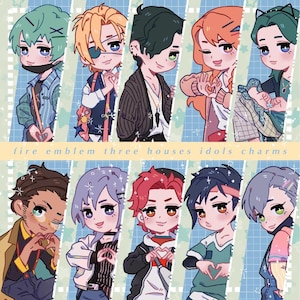 May include: A digital illustration featuring ten chibi-style characters arranged in two rows against a blue grid background. The text "fire emblem three houses idols charms" is centred horizontally. Each character displays unique hair colours and outfits.