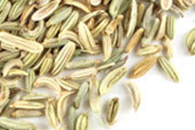 May include: Close-up of a pile of dried fennel seeds. The seeds are light green and brown in colour and have a slightly elongated shape.