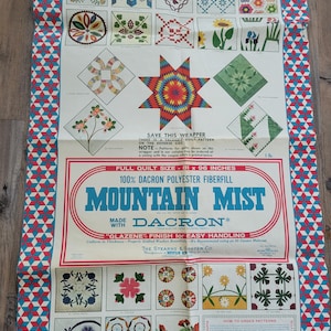 May include: Vintage Mountain Mist quilt batting wrapper. The wrapper features a red, white, and blue geometric border. The center displays quilt block patterns and the text "Mountain Mist" with "Dacron" fiberfill information. Full quilt size is 81 x 96 inches.