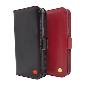 May include: Two leather phone cases are shown, one black and one red. The black case features red stitching and a red dot, while the red case has gold accents. Both cases have a magnetic clasp.