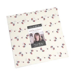 May include: Moda Fabrics American Gatherings II fabric collection featuring a white background with a repeating pattern of red, white, and blue American flags and stars. The Moda logo is in the center of the fabric with a photo of the designer,  Brenda Riddle.