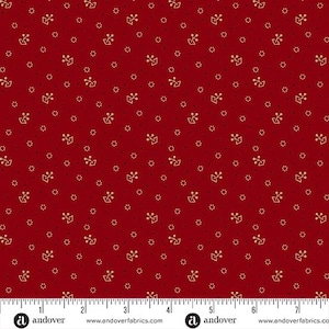 May include: Red fabric featuring a repeating pattern of small gold floral and dot designs. A ruler is along the bottom edge. The Andover Fabrics logo is visible.