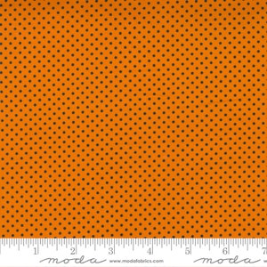 May include: Orange fabric with a black polka dot pattern. The fabric is measured with a ruler in inches.