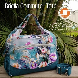 Può includere: Una borsa tote blu-verde con motivo floreale, una tasca con cerniera e una tracolla rimovibile. La borsa è etichettata "Briella Commuter Tote" e "Tan Made Australia".