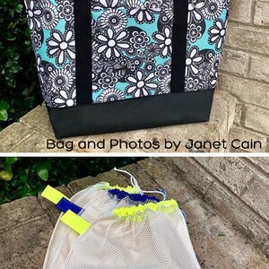 Pu&ograve; includere: Una borsa tote con un motivo floreale in turchese, nero e bianco, con manici neri e base nera. Sotto, sono esposti due sacchetti a rete con dettagli gialli e blu. Il testo "Bag and Photos by Janet Cain" &egrave; visibile.