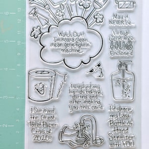 May include: A set of clear rubber stamps with various designs related to cleaning and hygiene. The stamps feature images of a toilet paper roll, a hand washing under a faucet, a bottle of hand sanitizer, a broom, a dustpan, and a spray bottle. The stamps also include text such as "I survived the Great Toilet Paper Crisis of 2020!" and "I'd share my last bottle of hand sanitizer with you."